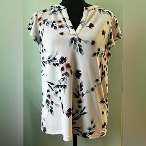 White, blue, and pink Calvin Klein blouse with capped, flowy sleeves.